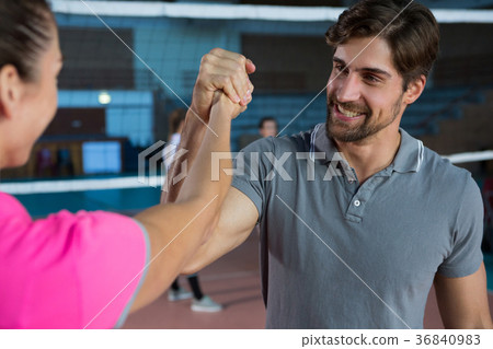 Determined volleyball player holding hand with teammate Determined volleyball player holding hand with teammate 36840983
