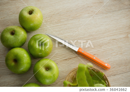 Close-up of granny smith apples by peel and kitchen knife 36841662
