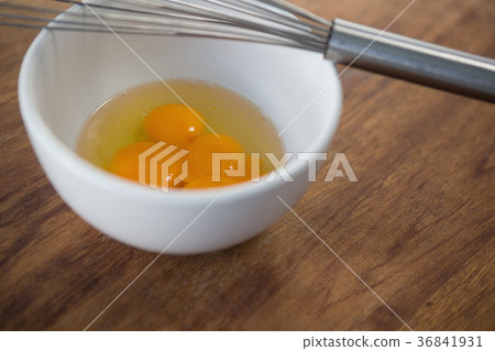 Close up of egg in bowl with wire whisk Close up of egg in bowl with wire whisk 36841931