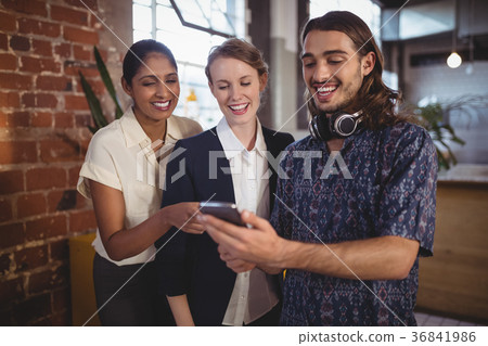 Young man showing smartphone to female friends at coffee shop Young man showing smartphone to female friends at coffee shop 36841986