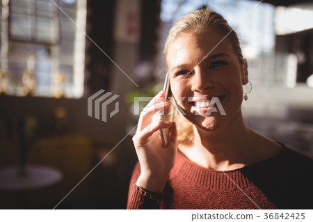Close up of smiling woman listening to mobile phone Close up of smiling woman listening to mobile phone 36842425