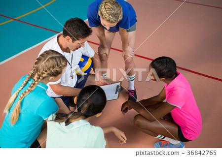Volleyball coach talking to female players Volleyball coach talking to female players 36842765