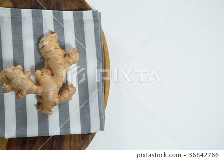 Overhead view of fresh ginger on striped napkin in plate 36842766