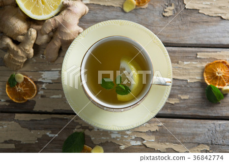 Directly above view of lemon and mint leaves in ginger tea on weathered table Directly above view of lemon and mint leaves in ginger tea on weathered table 36842774