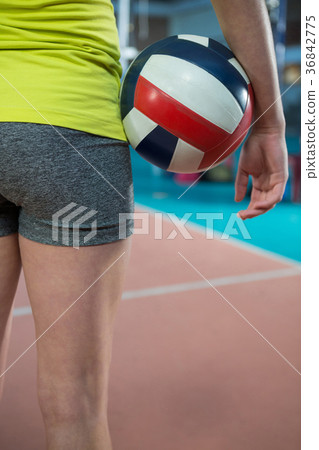 Female player standing with volleyball in the court Female player standing with volleyball in the court 36842775