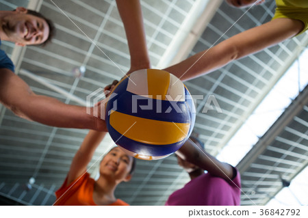 Coach and female players holding volleyball Coach and female players holding volleyball 36842792