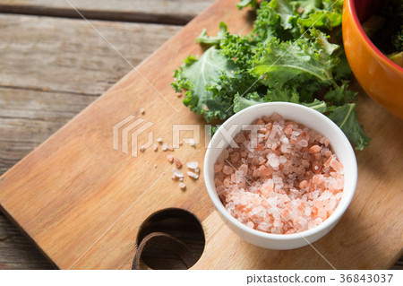 Fresh kale with rock salt on cutting board 36843037