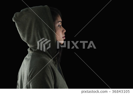 Thoughtful female athlete in hooded jacket 36843105