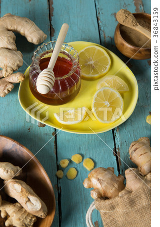 Lemon and gingers with honey jar on table Lemon and gingers with honey jar on table 36843159