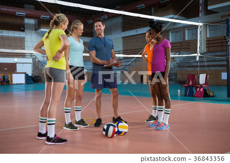 Volleyball coach talking to female players Volleyball coach talking to female players 36843356