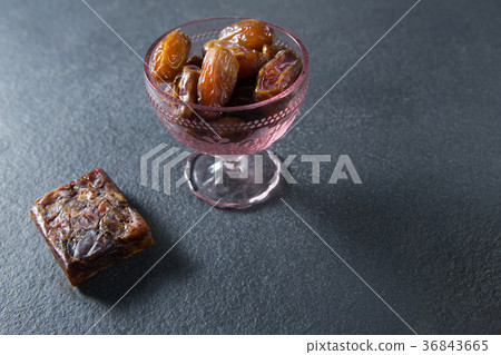 Dates fruits in glass bowl on slate Dates fruits in glass bowl on slate 36843665