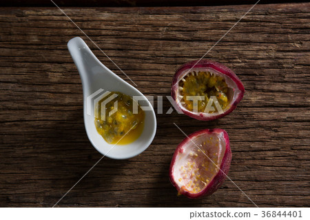 Two passion fruit and spoon with passion fruit pulp on wooden table Two passion fruit and spoon with passion fruit pulp on wooden table 36844401