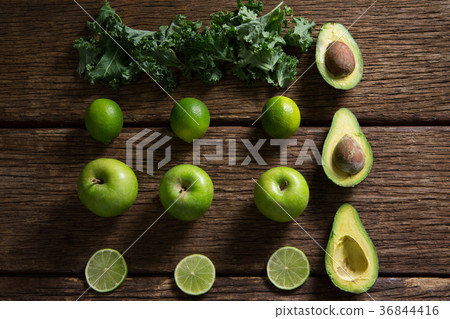 Mustard greens, lemon, avocado and green apple arranged on wooden table 36844416