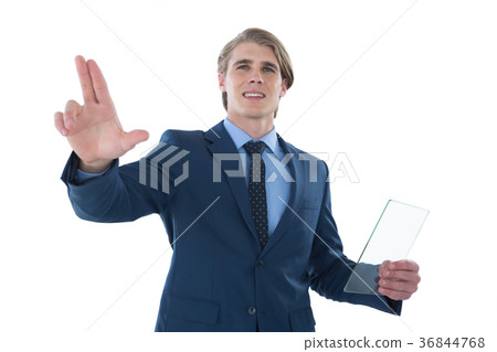 Businessman holding glass interface while touching imaginary screen Businessman holding glass interface while touching imaginary screen 36844768