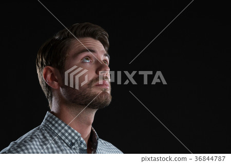 Man standing against black background Man standing against black background 36844787