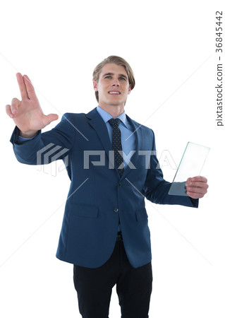 Young businessman holding glass interface while touching imaginary screen Young businessman holding glass interface while touching imaginary screen 36845442