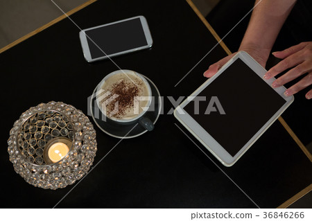 Overhead of woman using digital tablet while having coffee 36846266