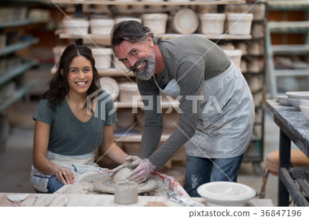 Portrait of male potter assisting female potter Portrait of male potter assisting female potter 36847196