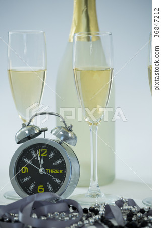 Champagne with alarm clock and glass on white background 36847212
