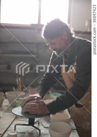 Male potter molding a clay 36847423