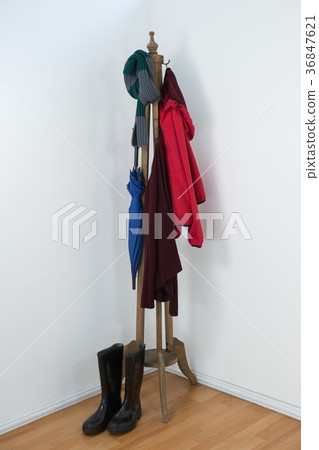 Warm clothes, umbrella, and wellington boots on wooden stand Warm clothes, umbrella, and wellington boots on wooden stand 36847621