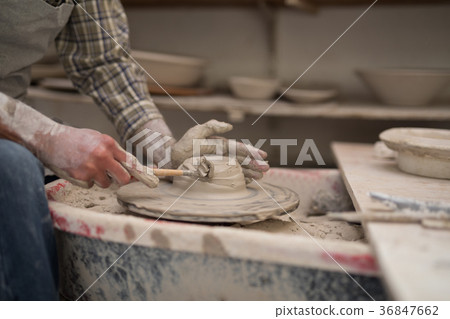 Mid section of male potter molding plate with hand tool Mid section of male potter molding plate with hand tool 36847662
