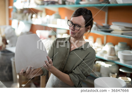 Female potter checking ceramic vase 36847666