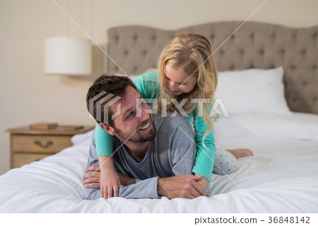 Father and daughter having fun on bed 36848142
