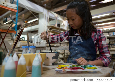 Attentive girl painting a bowl Attentive girl painting a bowl 36848596
