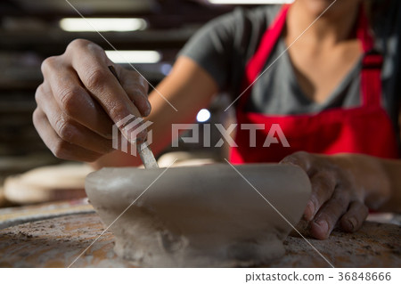 Female potter molding a bowl with hand tool Female potter molding a bowl with hand tool 36848666