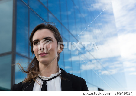 Female executive standing in office premises Female executive standing in office premises 36849034