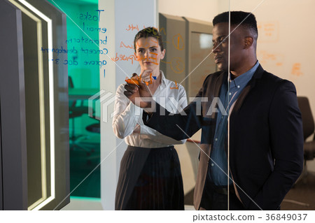 Male executive writing on glass Male executive writing on glass 36849037