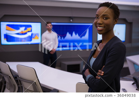 Male and female executives standing in boardroom Male and female executives standing in boardroom 36849038