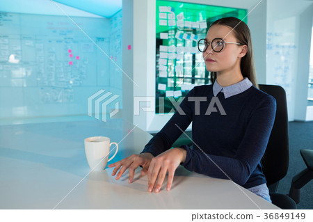 Female executive gesturing at desk 36849149