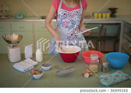 Waitress preparing food while using digital tablet in restaurant Waitress preparing food while using digital tablet in restaurant 36849168