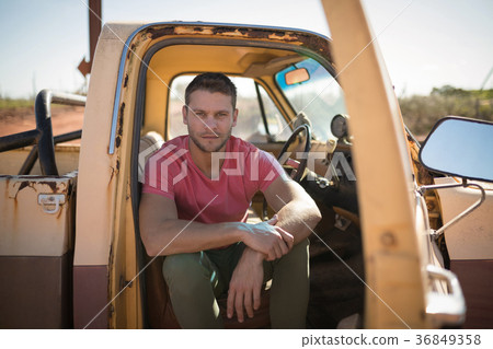 Man sitting in a car on a sunny day 36849358