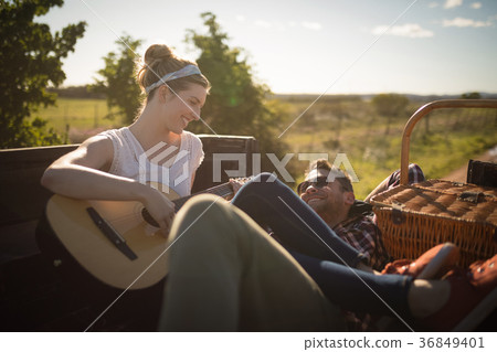 Woman playing guitar while man listening in a car Woman playing guitar while man listening in a car 36849401