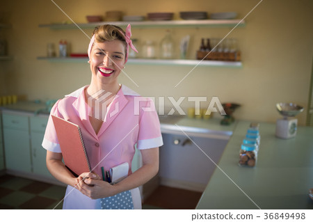 Waitress standing with menu card in restaurant 36849498