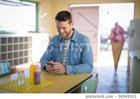 Man using mobile phone in restaurant 36849501