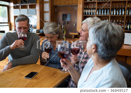 Group of senior friends having red wine Group of senior friends having red wine 36849527