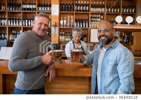 Two men having glass of bear at counter in restaurant Two men having glass of bear at counter in restaurant 36849528