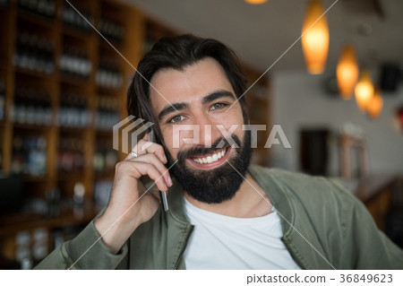 Smiling man talking on mobile phone Smiling man talking on mobile phone 36849623
