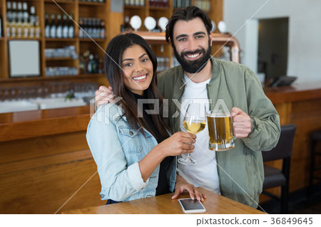 Smiling couple having drinks in bar 36849645