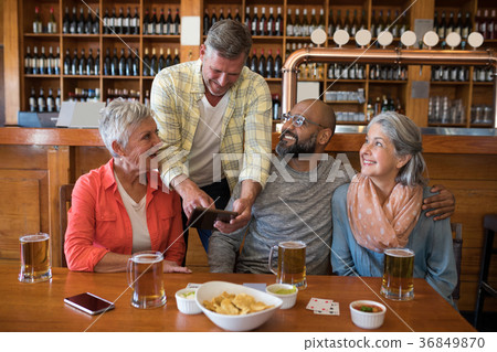 Friends sitting together at bar 36849870