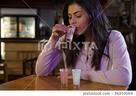 Woman drinking tequila shot 36850069