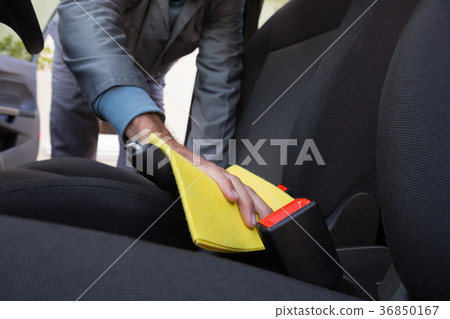 Worker cleaning seat inside the car Worker cleaning seat inside the car 36850167