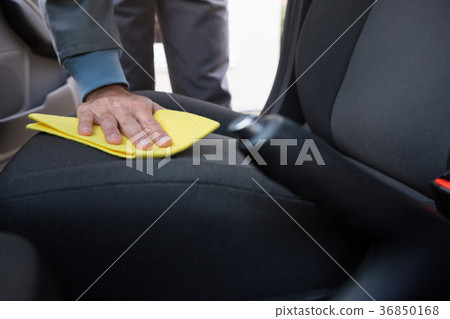 Worker cleaning seat inside the car Worker cleaning seat inside the car 36850168