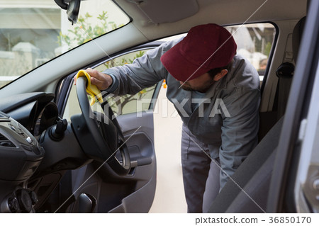 Auto service staff cleaning car interior 36850170