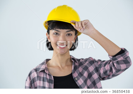 Female architect in hard hat standing against white background Female architect in hard hat standing against white background 36850438