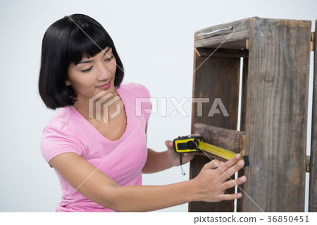 Woman measuring furniture with tape measure 36850451